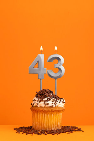 Birthday candle number 43 - Invitation card with orange background. cupcakeの写真素材