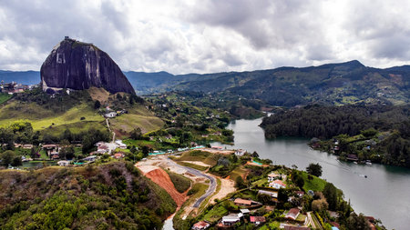 Guatape, Antioquia - Colombia. November 23, 2025. Aerial view of the PeÃ±ol rock surrounded by green mountains, the reservoir, and small rural houses.の写真素材