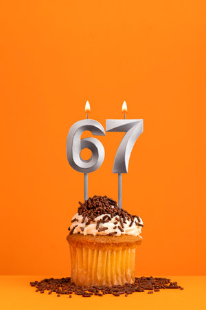 Birthday candle number 67 - Invitation card with orange background. cupcakeの写真素材