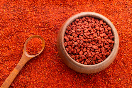 Crushed annatto seeds in the spoon and in the bowl - Bixa Orellanaの写真素材