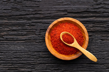 Ground or crushed organic annatto in the spoon and in the bowl - Bixa orellanaの写真素材