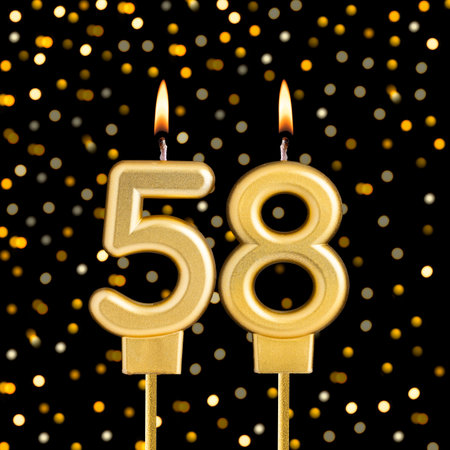 Number 58 birthday candle on a black background with blurred lights