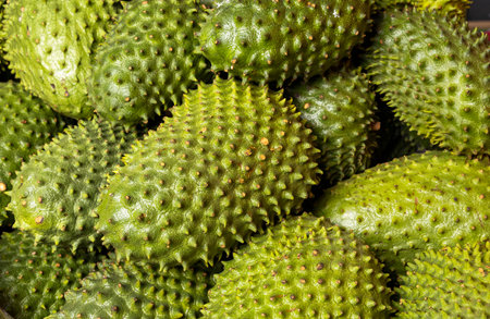 Soursops for sale in a traditional Colombian market, highlighting the color, texture, and freshness...