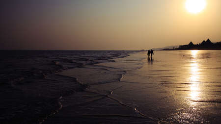 A couple is wondering in the beach in the eveningの写真素材