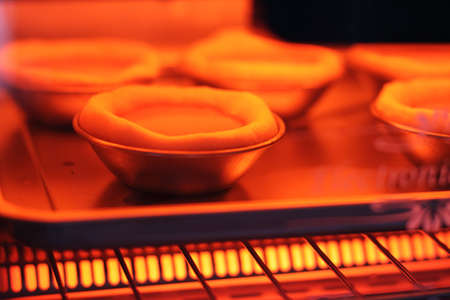 Baking eggtart in electric ovenの写真素材