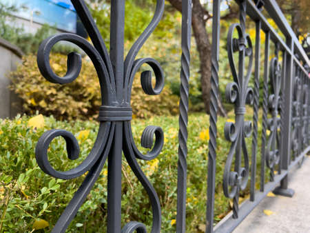 Close up of a part of a black metal fence on the street