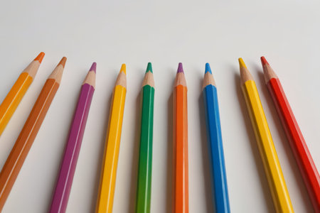 several colored pencils lined up in a row on a white surfaceの素材