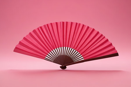 a close up of a red fan on a pink backgroundの素材