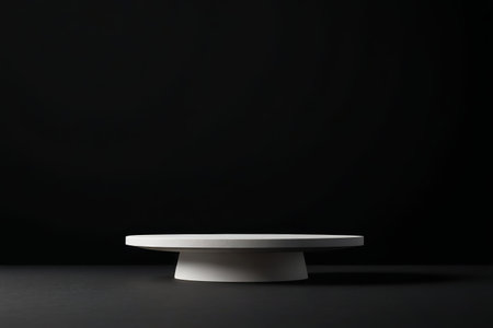 a close up of a white cake plate on a black surfaceの素材