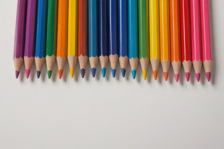 a close up of a row of colored pencils on a white surfaceの素材