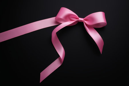 Pink ribbon bow on black backgroundの素材