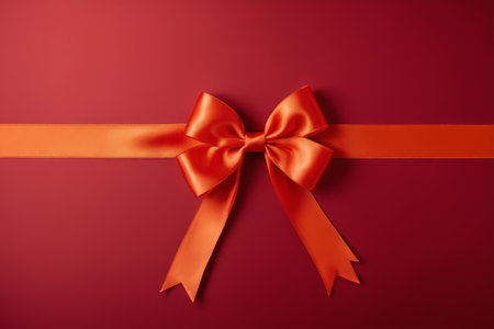 Orange ribbon bow on red backgroundの素材