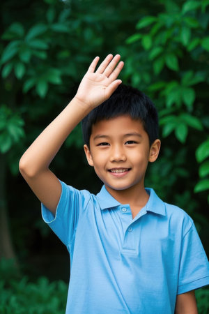 Boy waves happily outdoorsの素材