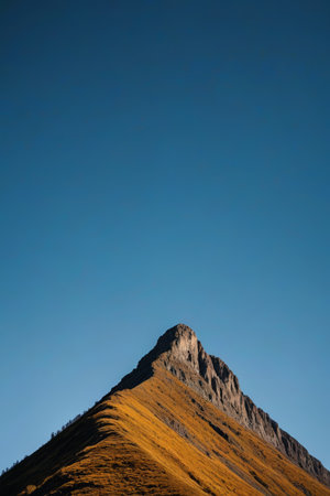 mountains with a few trees on top of them and a clear blue skyの素材