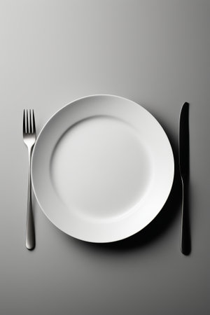 White dinner plate with knife and fork on the tableの素材