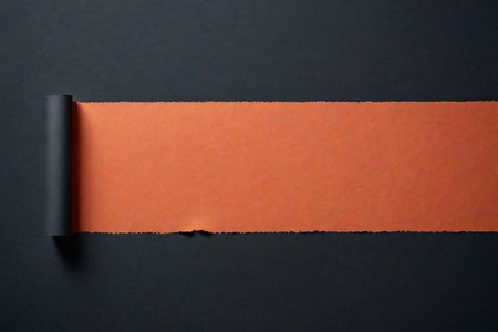 Orange curled paper on black backgroundの素材