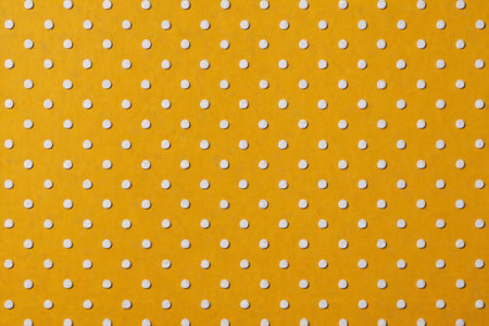 White polka dot pattern on yellow backgroundの素材