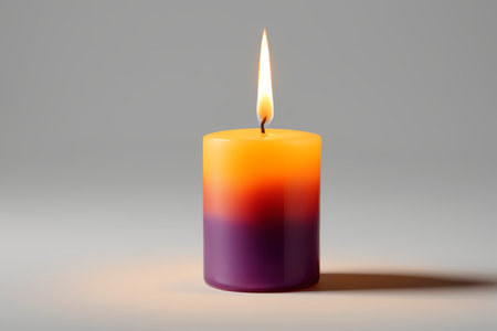 a close up of a candle with a single flame on a gray backgroundの素材