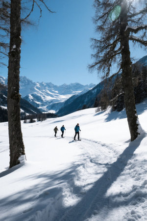 Three-person hiking and skiing scene in the snow-capped mountainsの素材