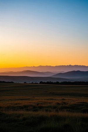 Panoramic view of the grassland sunset and distant mountainsの素材