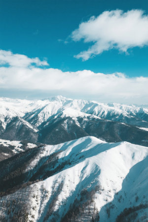 Snowy mountain scenery under blue sky and white cloudsの素材