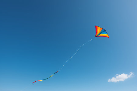 Colorful kites flying in the blue skyの素材