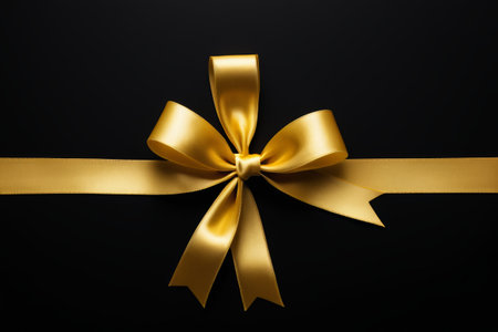 Gold ribbon bow on black backgroundの素材