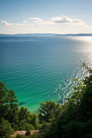 Blue sea surrounded by green trees on the coastの素材