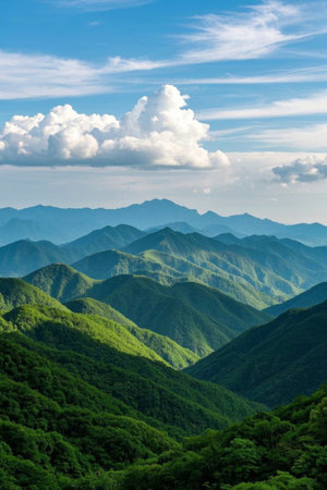 Linking green mountains under blue sky and white cloudsの素材