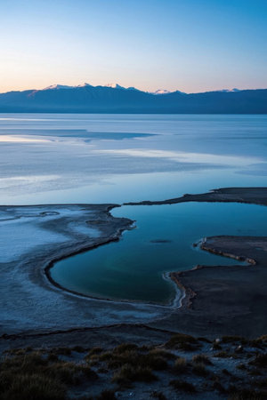 Calm lake and distant snow capped mountainsの素材