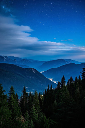 The mountains and forests under the night sky and the distant townscapeの素材