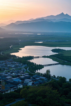 Panoramic view of sunrise in a village amidst mountains and riversの素材