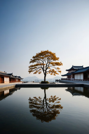 Landscape of a lone tree by the water next to a Chinese buildingの素材