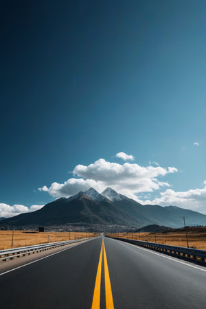 The road extends towards the distant mountain landscapeの素材