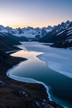 Calm lake scenery at the foot of the snow capped mountainsの素材