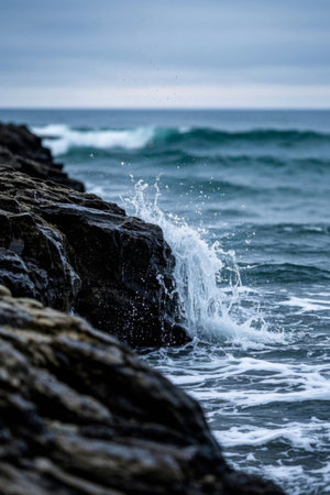 Waves crashing against the rocky landscape on the shoreの素材