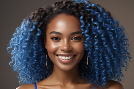 Portrait of a woman of African descent with blue hair and smilingの素材