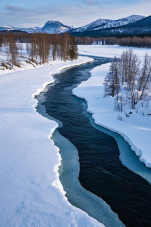 Snow covered rivers and distant mountain scenery in winterの素材