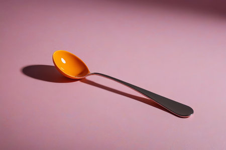 Orange spoon on pink backgroundの素材