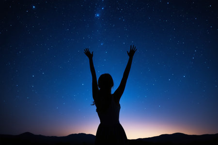 Silhouette of a woman stretching her arms under the night skyの素材