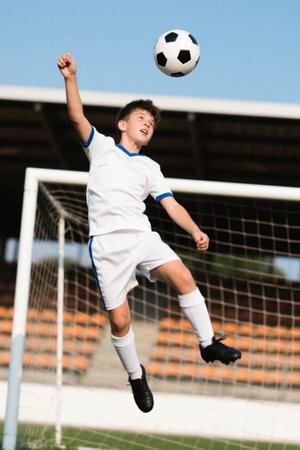 Young football player leaps into the air to kick the ballの素材