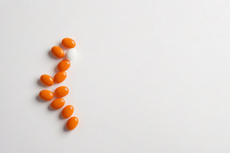 Orange and white pills on white backgroundの素材