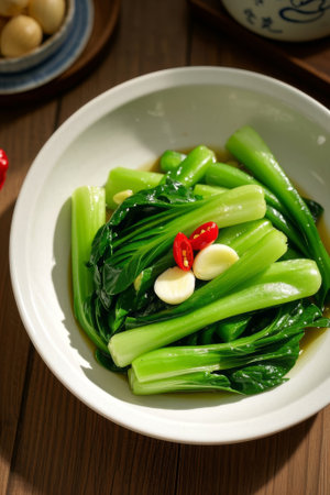 Stir fried greens with chili garlic on a white plateの素材