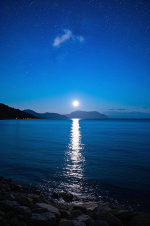 The sea and distant mountain landscape under the moonlit nightの素材