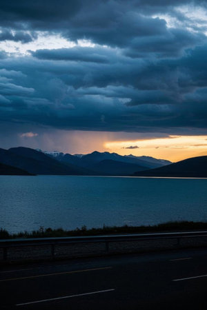 Mountains and road landscape under dark clouds by the lakeの素材