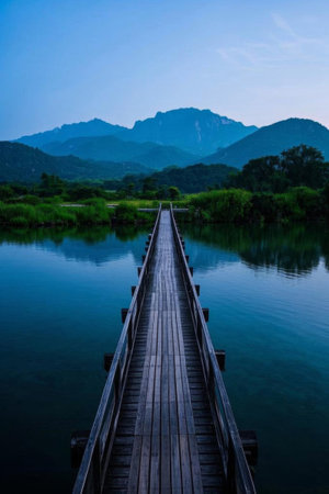 Wooden bridge over the lake and distant mountain sceneryの素材