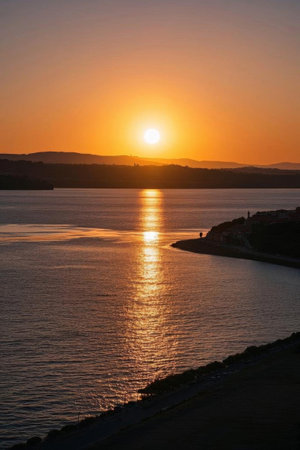 The water and distant mountains at sunsetの素材