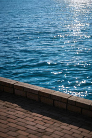 The blue sea on the shore is shimmering with sunlightの素材