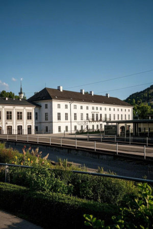 Railway tracks and green landscape next to the white buildingの素材
