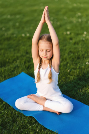Outdoor little girl doing yoga meditationの素材